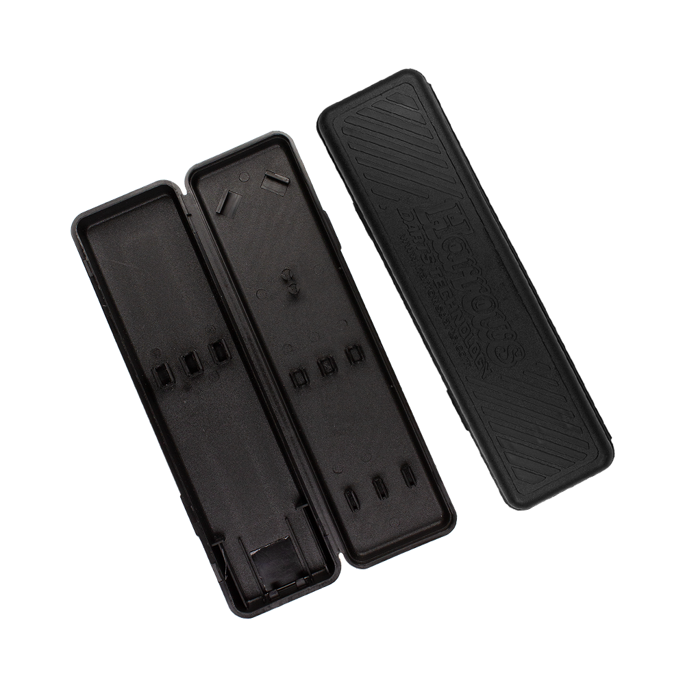 Plastikbox-Harrows6zrmsWC1nCUzw Das Bild zeigt ein leeres, geöffnetes schwarzes Darts-Etui der Marke Harrows. Der Deckel mit der Aufschrift „Harrows“ liegt neben dem Etui.