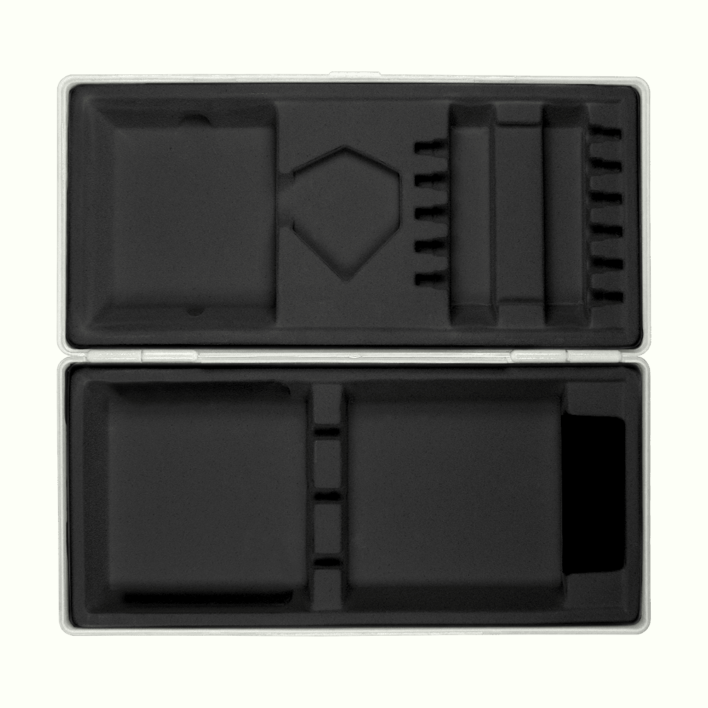 ABS krabice s vlastním potiskem Die Abbildung zeigt eine geöffnete graue Box mit passgenauen Fächern aus schwarzem Schaumstoff. Die Box liegt auf einem hellgelben Hintergrund.