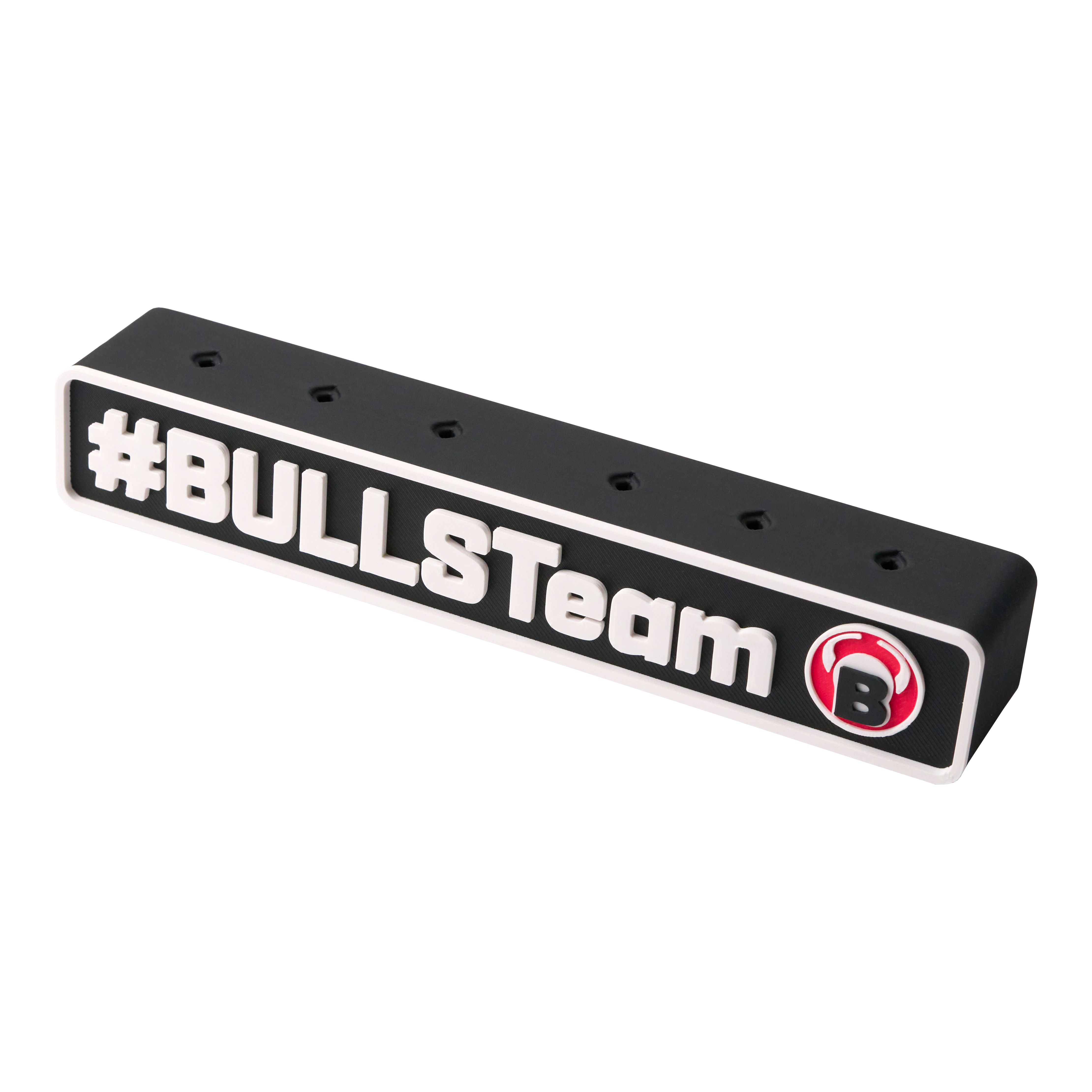 Das Bild zeigt einen schwarzen Darts-Halter mit der Aufschrift "#BULLSTeam" und einem roten Bullen-Logo. Der Halter hat mehrere Löcher zur Aufbewahrung von Dartpfeilen.