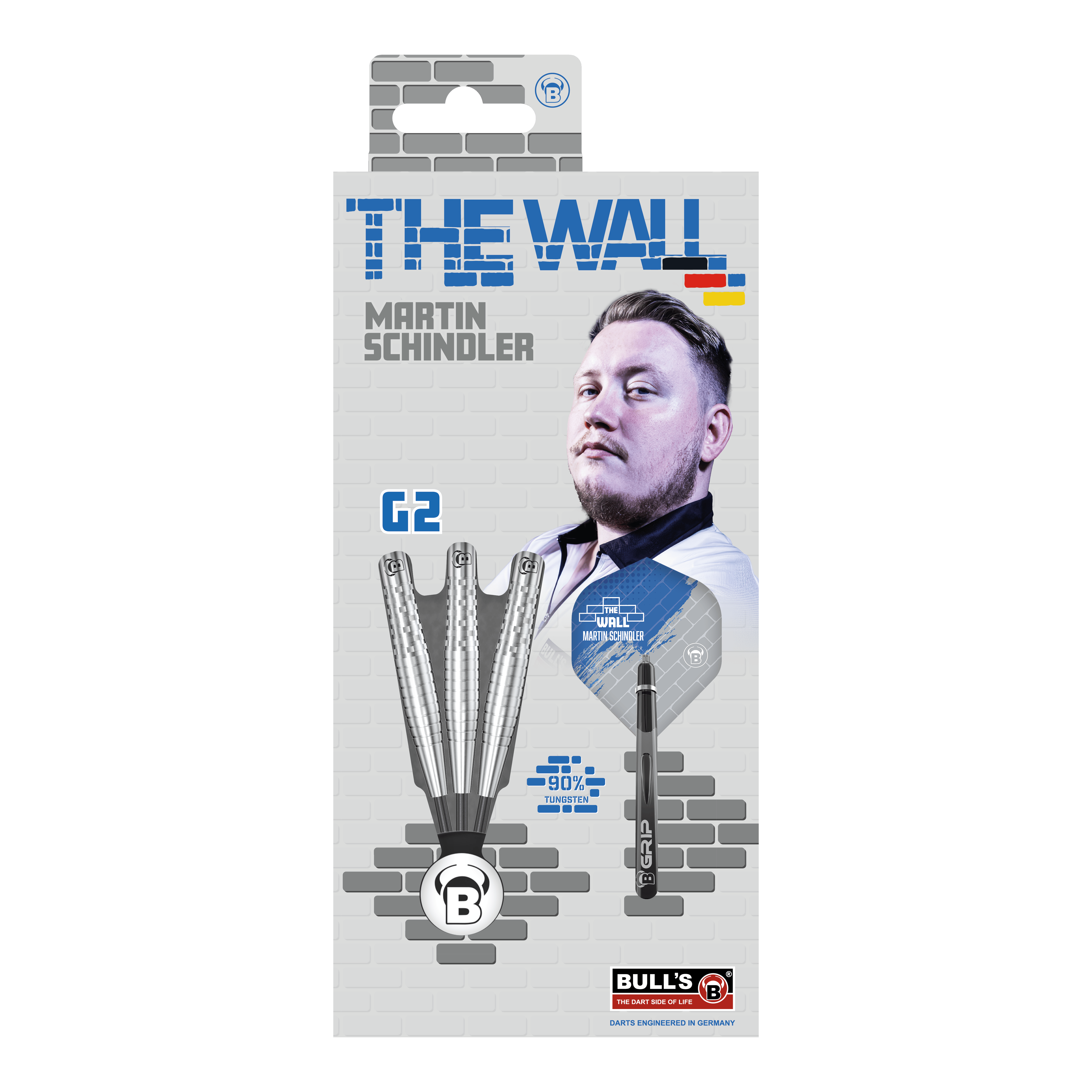 Ocelové šipky Bulls Martin Schindler Original Generation 2 Die Verpackung zeigt die "Bulls Martin Schindler Original Generation 2 Steeldarts" mit dem Bild von Martin Schindler. Auf der Vorderseite sind drei Darts und die Aufschrift "THE WALL" sowie "90% Tungsten" abgebildet.