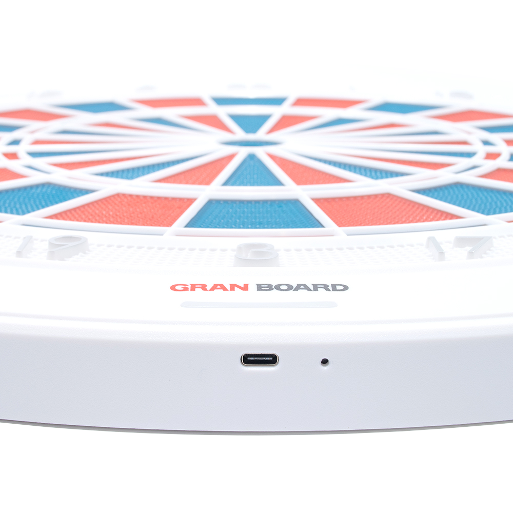 g01440_GranBoard_132_Elektronisches_Dartboard_3 Das Bild zeigt das elektronische Dartboard „GranBoard 132“ mit einem modernen, farbigen Design. Im Vordergrund ist der USB-Anschluss des Geräts gut sichtbar.