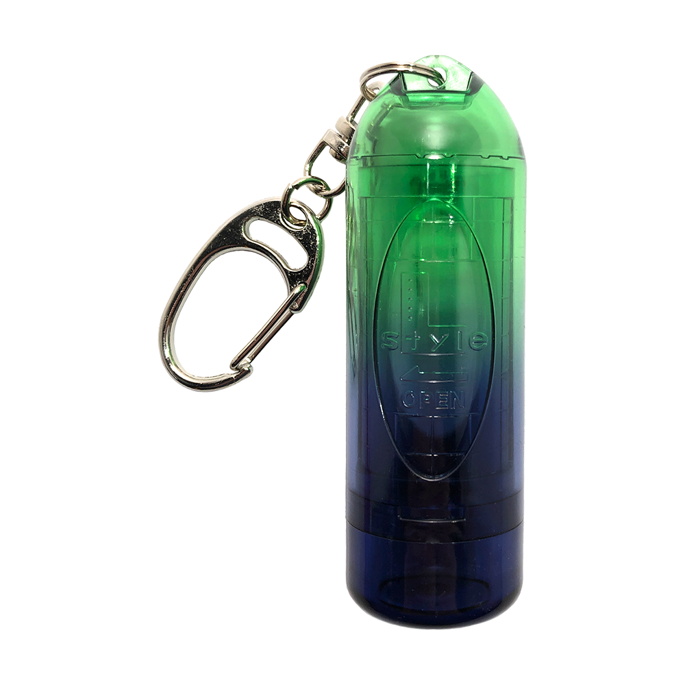 L9LIPSTOCK-IdealGreen_L-Style_Lipstock_Twin_Color_Ideal_Green_Spitzencase_1 Das Bild zeigt das Produkt "L-Style N9 Lipstock Twin Color Spitzencase" in den Farben Grün und Blau. Das Spitzencase ist mit einem silbernen Karabinerhaken ausgestattet.