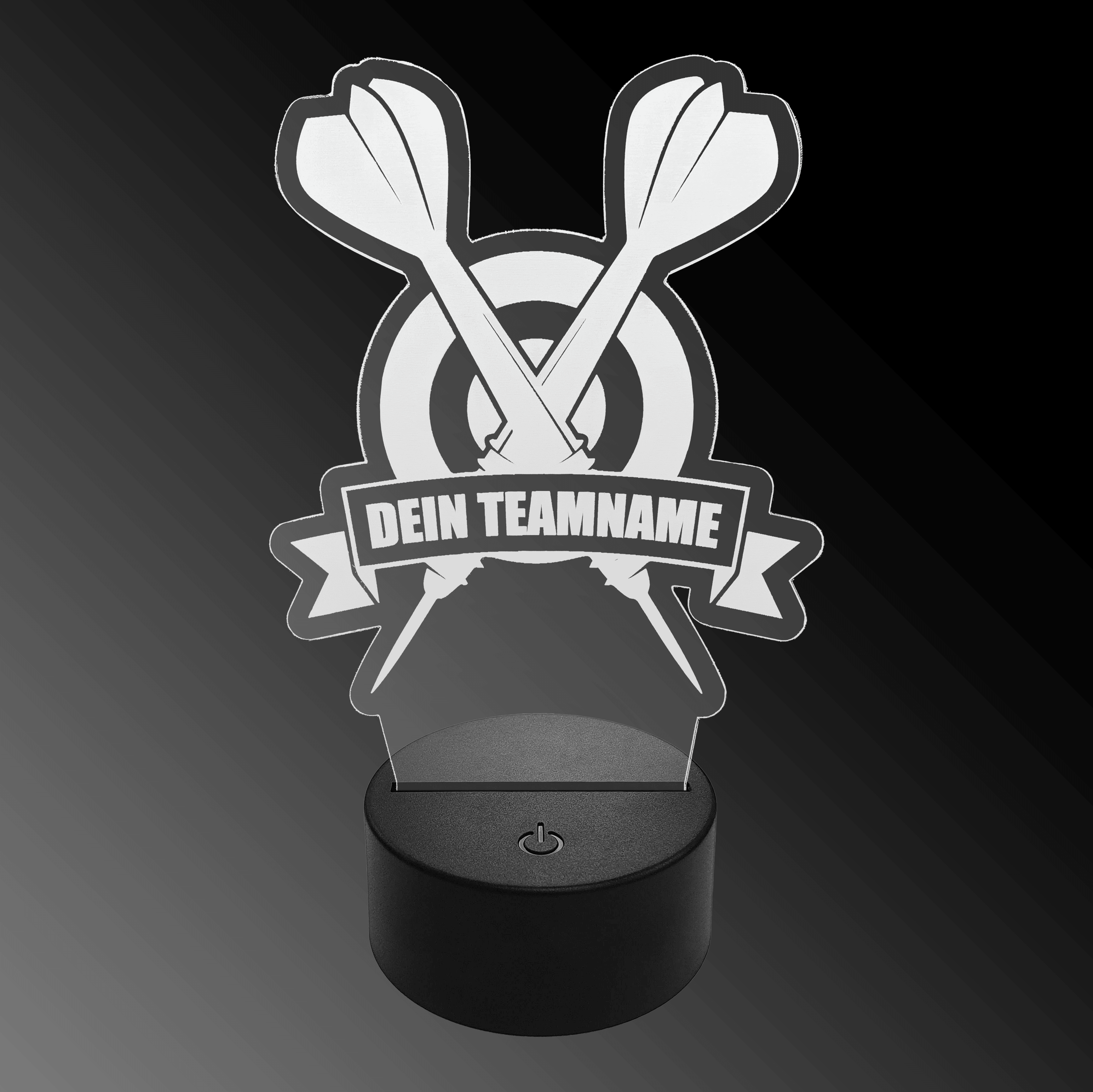 LED plexisklová šipková lampa s vlastním textem Das Bild zeigt eine LED-Lampe aus Plexiglas in Form von zwei gekreuzten Dartpfeilen vor einer Zielscheibe. Auf einem Banner steht der Text "DEIN TEAMNAME".