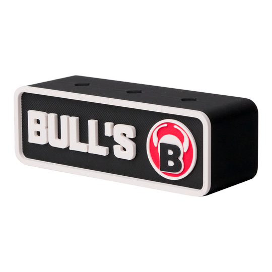 Das Bild zeigt einen schwarzen Dartshalter mit der Aufschrift "BULL'S" und einem roten Bullenkopf-Logo. Der Halter ist rechteckig und hat drei Löcher auf der Oberseite für Darts.