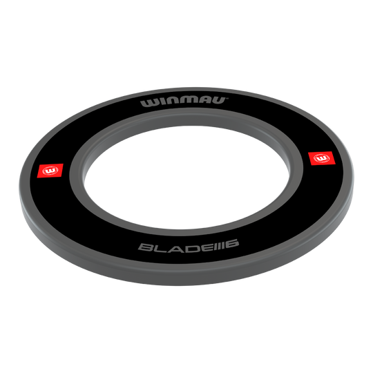 Das Bild zeigt das Winmau Pro-Line 1.0 Dartboard Surround in Schwarz. Es ist ein runder Schutzring mit dem Winmau-Logo und der Aufschrift "BLADE IIII 6".