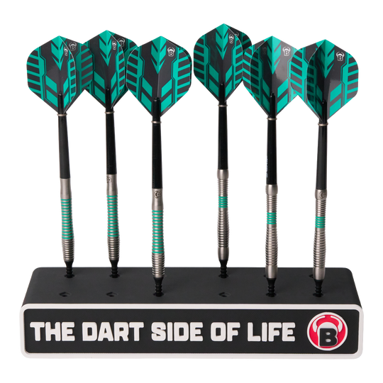 Das Bild zeigt sechs Dartpfeile in einem schwarzen Ständer. Auf dem Ständer steht der Schriftzug „THE DART SIDE OF LIFE“ mit einem roten B-Logo.