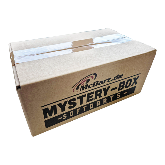 Auf dem Bild ist ein Karton mit der Aufschrift "McDart Mystery-Box - Softdarts" zu sehen. Der Karton ist zugeklebt und sieht aus wie ein Überraschungspaket.