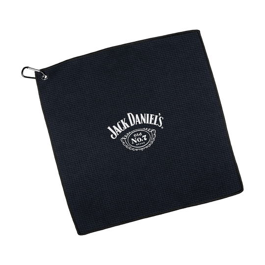 JD7032_Mission_Jack_Daniels_Handtuch_1 Dies ist ein schwarzes Handtuch mit dem weißen Jack Daniel's Logo in der Mitte. In der Ecke befindet sich eine Metallöse mit einem Haken zum Aufhängen.