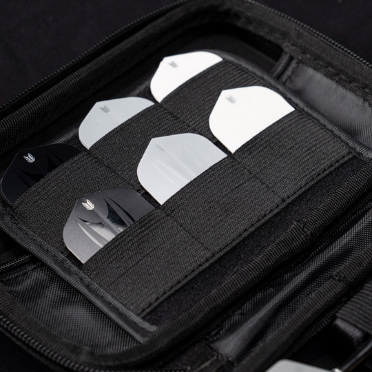 Pouzdro na šipky Target Takoma Luke Littler XL Das Bild zeigt das „Target Takoma Bolide XL Dartcase“, das mehrere Dart-Flights in schwarzen und weißen Farben organisiert aufbewahrt. Die Flights sind sicher in elastischen Halterungen im Inneren des schwarzen Etuis verstaut.