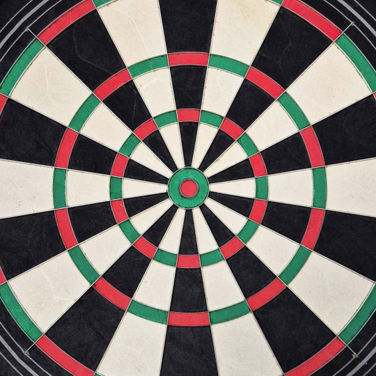 Ocelový terč Harrows Quadro 240 Das Bild zeigt eine Nahaufnahme des Harrows Quadro 240 Steeldartboards. Das Dartboard ist in verschiedene Abschnitte in den Farben Schwarz, Weiß, Rot und Grün unterteilt.