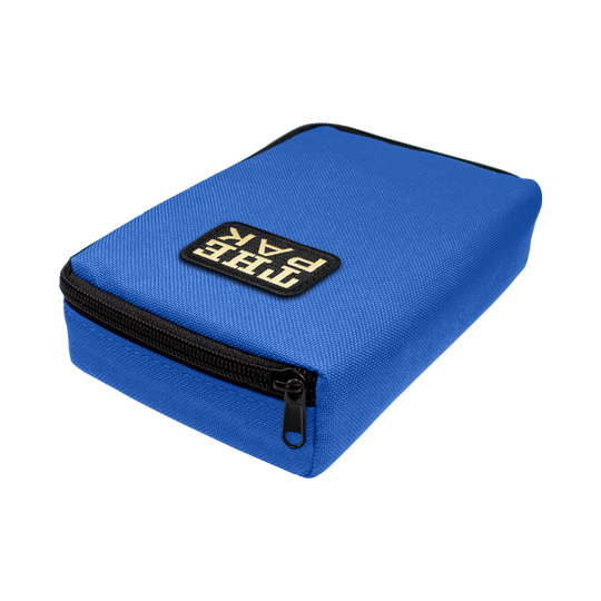 707TP_The_Pak_Dartcase_Blau_2 Das Bild zeigt ein blaues Etui mit einem schwarzen Reißverschluss. Auf der Oberseite befindet sich ein Patch mit der Aufschrift "THE PAK".