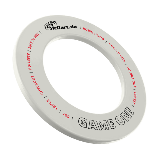 McDart Game On Dartboard Surround Das Bild zeigt einen weißen Dartboard-Surround-Ring mit der Aufschrift "McDart.de" und "GAME ON!". Auf dem Ring stehen außerdem in roter Schrift Begriffe rund um das Dartspiel wie "BULLSEYE", "TRIPLE", "CHECKOUT" und "CRICKET".