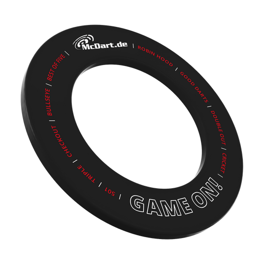 Das Bild zeigt einen schwarzen Dartboard-Surround-Ring mit der Aufschrift "McDart.de" und "GAME ON!". Um den Ring sind weitere Begriffe rund um das Dartspiel in Rot und Weiß geschrieben.