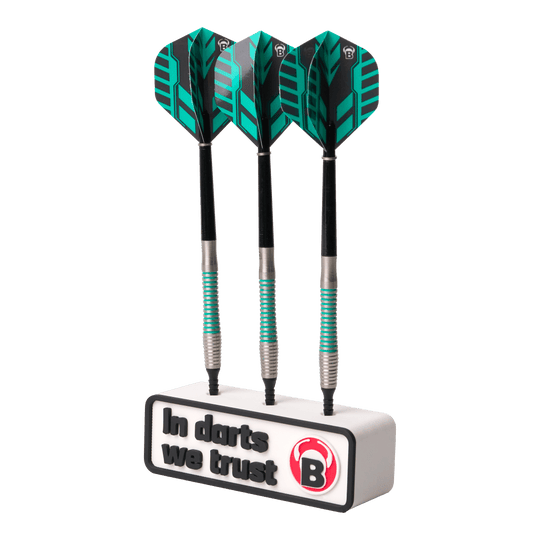 Das Bild zeigt drei Darts, die in einem weißen Halter stecken. Auf dem Halter steht der Text "In darts we trust" zusammen mit einem roten B-Logo.