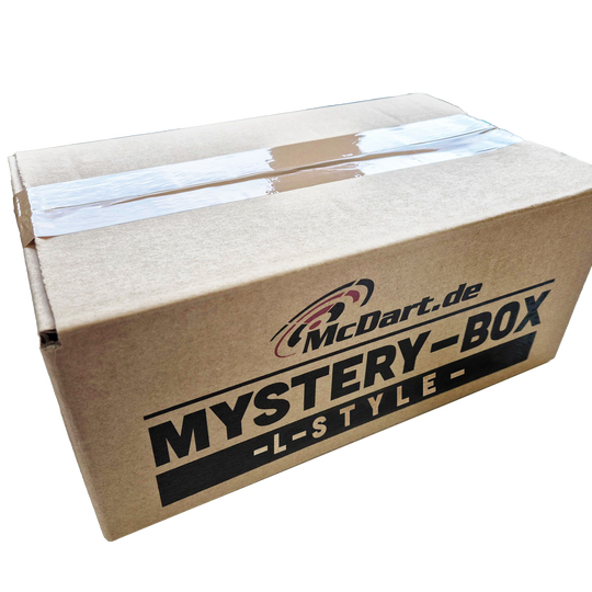 McDart Mystery Box – styl L Auf dem Bild ist ein brauner Karton mit der Aufschrift „McDart.de MYSTERY-BOX -L-STYLE-“ zu sehen. Die Box ist mit Klebeband verschlossen.