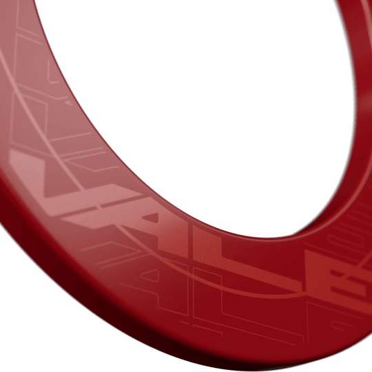 Obložení terče Target VALE Das Bild zeigt einen roten Dartboard-Surround mit dem Schriftzug "VALE". Der Ring hat ein modernes, glänzendes Design und ist für den Schutz der Wand um das Dartboard gedacht.