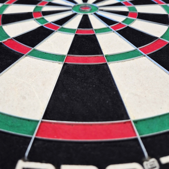 Ocelový terč Harrows Quadro 240 Das Bild zeigt eine Nahaufnahme des Harrows Quadro 240 Steeldartboards. Die Farbfelder in Schwarz, Weiß, Rot und Grün sind deutlich zu erkennen.