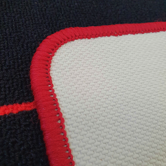 McDart Tops Dartteppich Das Bild zeigt eine Nahaufnahme des McDart Lines Dartteppichs. Deutlich sichtbar sind die rote Umrandung und die feine Gewebestruktur der Matte.